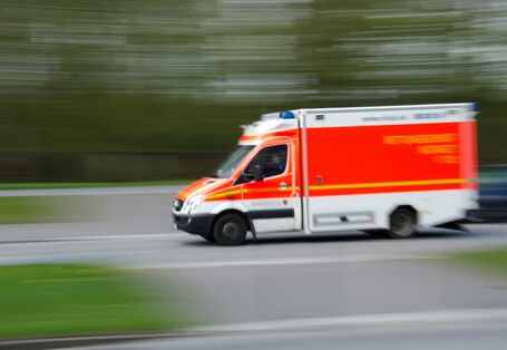 Ein Bild zeigt einen fahrenden Krankenwagen.