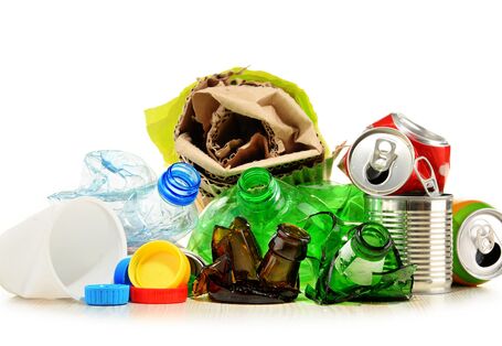 The photo shows packaging waste: Cans, bottles, paper. 