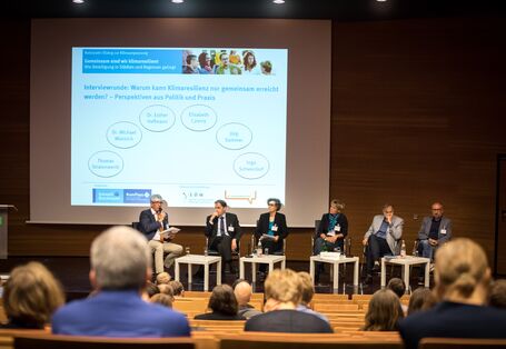 Blick auf das Podium im Hörsaal auf die Interviewrunde: Warum kann Klimaresilienz nur gemeinsam erreicht werden ?