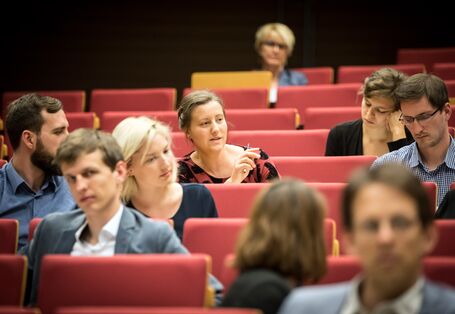 Blick auf miteinander diskutierende Veranstaltungsteilnehmerinnen und -teilnehmer  im Hörsaal.