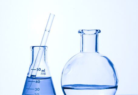 Zwei unterschiedliche Reagenzgläser, mit Flüssigkeit gefüllt, stehen nebeneinander.