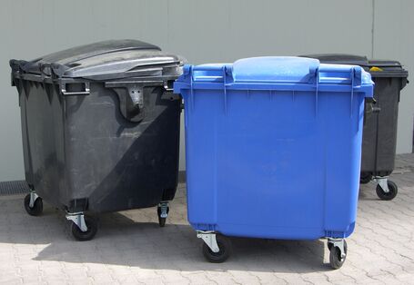 Drei große Müllcontainer für Altpapier und Restmüll
