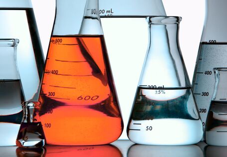 Glaskolben und -gefäße im Labor mit roter Flüssigkeit