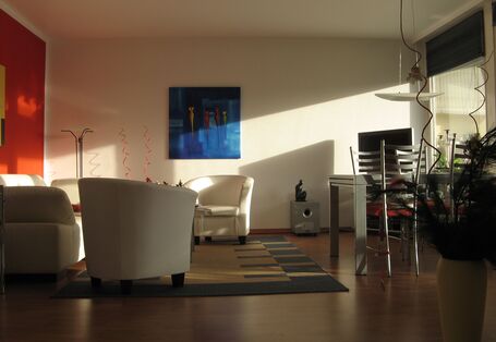 Wohnzimmer mit Sesseln, Teppich, Bilder, Esstisch