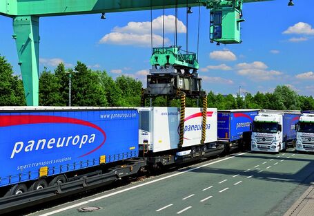 Paneuropa Anhänger werden von einem grünen Kran auf von Schienen auf die Straße verladen