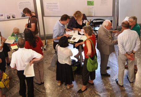 Personen stehen in Gruppen zusammen und tauschen sich aus.