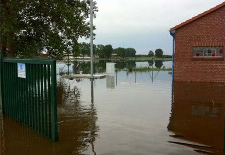 Fotografie einer Überflutung eines Hofs bzw. Parkplatzes.
