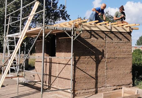 Praktikant*innen bei der Hanffaser Uckermark eG bauen ein Gebäude unter Nutzung von Hanfbaustoffen.