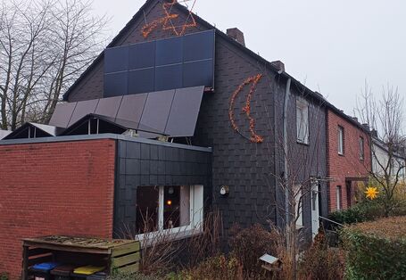 Ein schieferverkleidetes Reihenendhaus mit einstöckigem Anbau an der Giebelseite