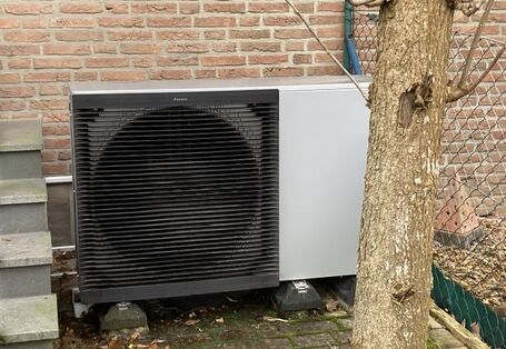 Die Außeneinheit einer Wärmepumpe an einer Hausfassade.