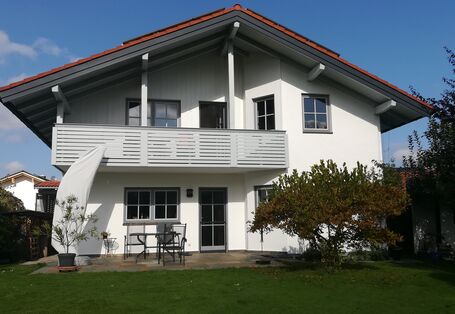 Ein weißes Einfamilienhaus mit Garten.