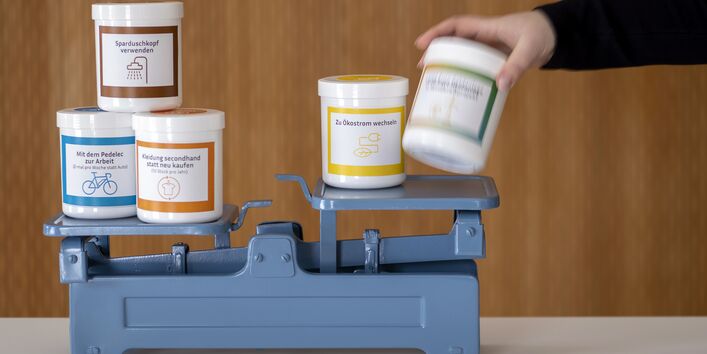 Die Klimawaage zeigt spielerisch anhand verschiedener, beschrifteter Dosen, die gegeneinander abgewogen werden können,, wie Alltagsentscheidungen das Klima beeinflussen.