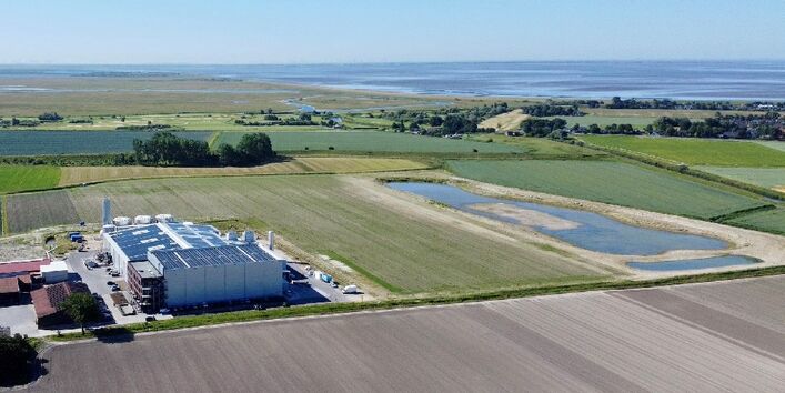 Ansicht der Produktionsstätte von oben, dahinter die Abwasseranlage und die Lagune.