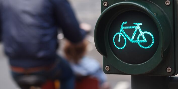 Fahrradampel steht auf Grün, Mann mit gelbem Rad ist vorbeigefahren