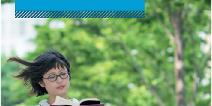 Eine Frau sitzt im Grünen und liest ein Buch