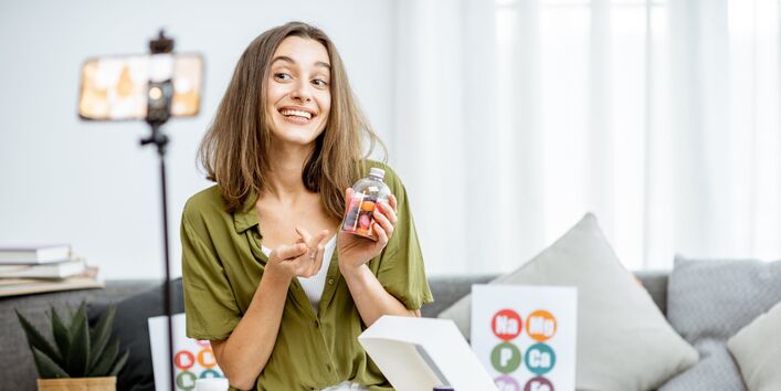Eine Frau nimmt ein Werbevideo mit dem Smartphone auf.