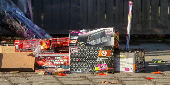 Abgebrannte Feuerwerkskörper und leere Verpackungen liegen auf einem gepflasterten Boden.