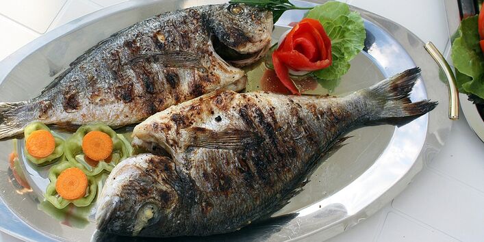 Zwei gegrillte Fische auf einem Tablett servierfertig angerichtet