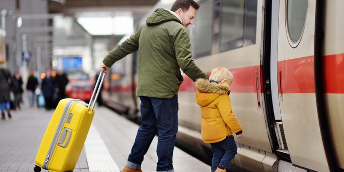 Ein Mann und ein Kind steigen in einen Zug ein.