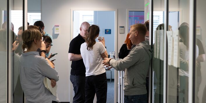 Viele Personen tauschen sich im Gespräch zu Themen der Künstlichen Intelligenz und Daten aus.