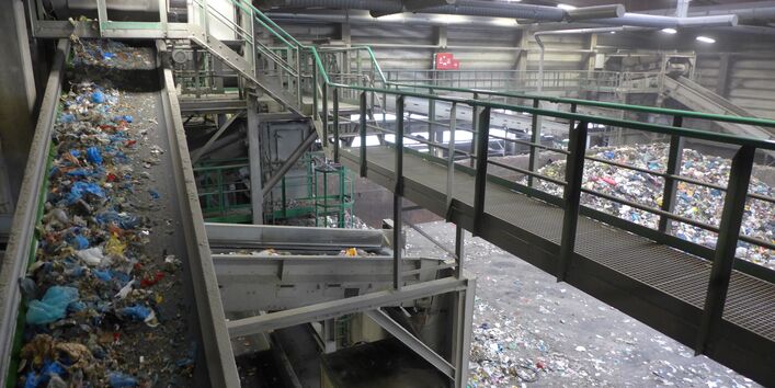 Mixed waste on a conveyer belt in a waste treatment plant
