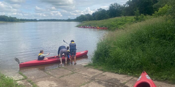 Teilnehmende der UBAwegs Tour im Mai steigen für die Paddeltour in ein Boot ein
