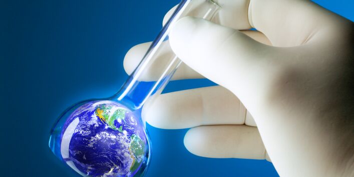 Eine Hand hält ein Reagenzglas, in dem sich sinnbildlich ein Abbild der Erde befindet.