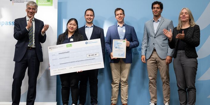 Stefan Tidow und Dr. Bettina Rechenberg überreichen einen Scheck an die Gewinner des Unternehmens inventied GmbH.