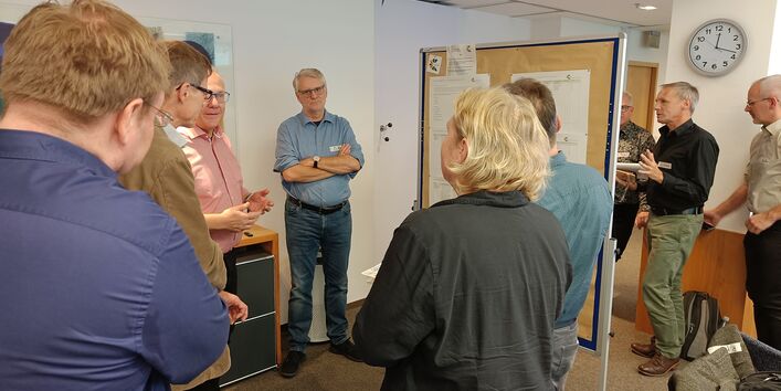 A group of people standing in a circle having a discussion