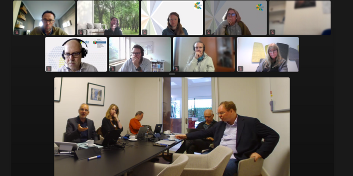 A screenshot  of a hybrid meeting, held in person and online.