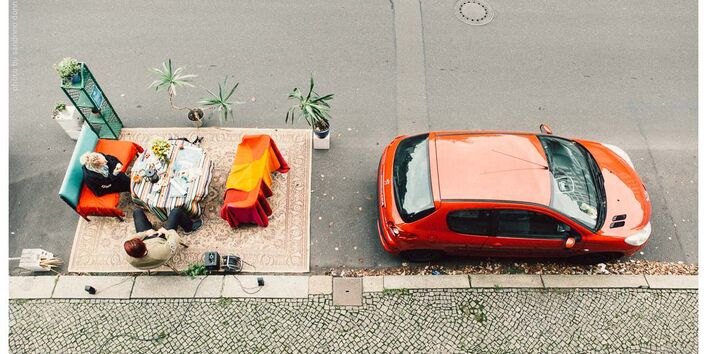 Hinter parkendem Fahrzeug wurde Wohnzimmer auf Parkplatz eingerichtet