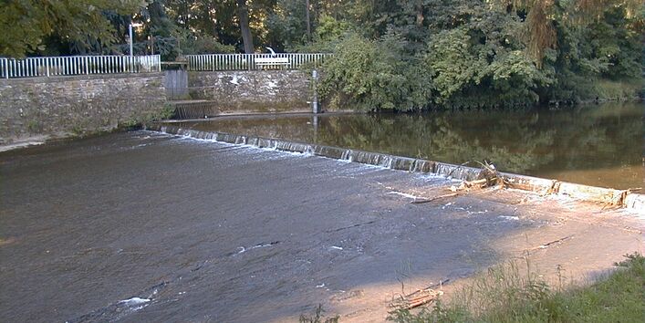 Foto: Seitlicher Blick auf Absturz mit darauffolgender, glatter Rampe. Oberhalb des Wehrs staut sich das Wasser.