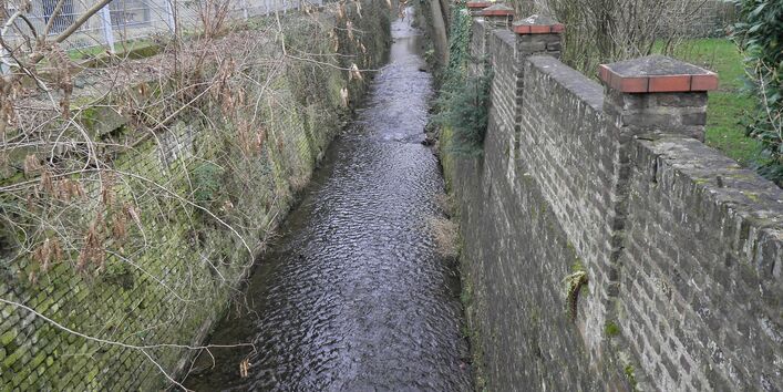 A straightened creek in Bonn, which is bordered on both sides with walls over 3 m high.