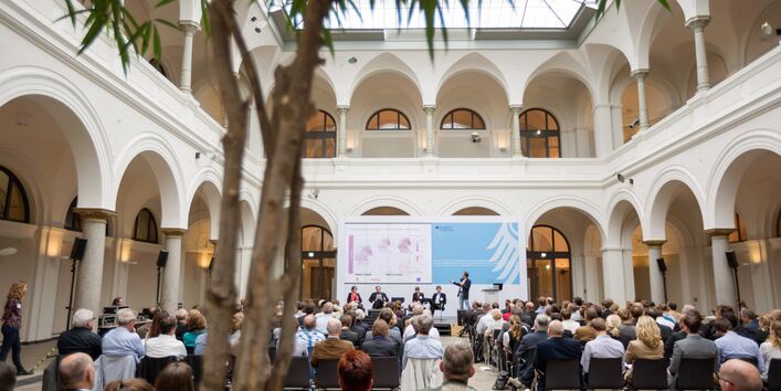 Das Publikum sieht einer Präsentation zur regionalen Auswirkung der Folgen des Klimawandels in Deutschland zu