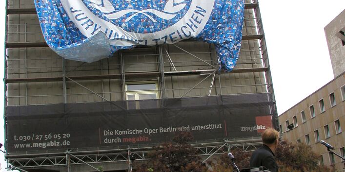 Zum 25-jährigen Jubiläum des Blauen Engel wurde ein riesiges Plakat an einer Hausfassade entrollt. 