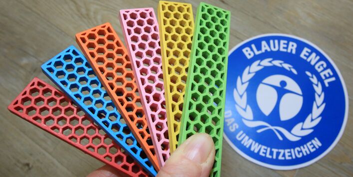 Bioblo-bausteine vor einem Logo des Blauen Engel