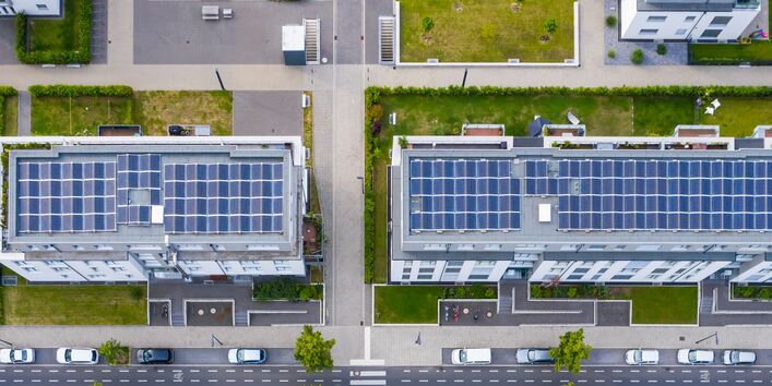 Luftbild eines Stadtquartiers mit Grünanlagen und Solarpanelen auf den Dächern.