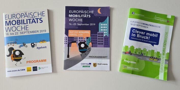 Drei Programmhefte der Europäischen Mobilitätswoche in unterschiedlichem Design aus Essen, Leipzig und Fürstenfeldbruck