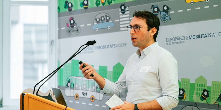 Günter Rasch steht an einem Stehpult und präsentiert