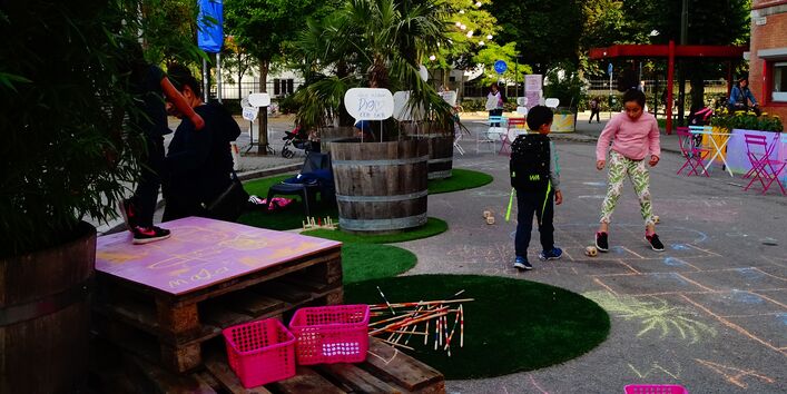 Kinder spielen auf gesperrter Straße und malen mit Kreide
