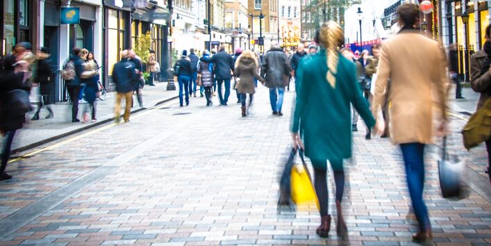 Menschen gehen durch eine belebte Einkaufsstraße