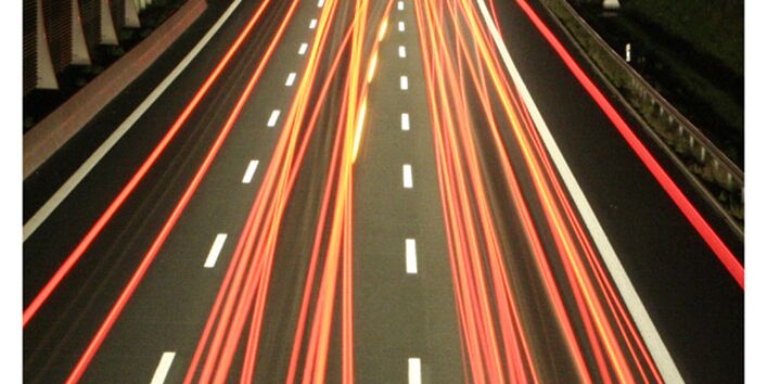 Cover von "Anpassung an den Klimawandel: Verkehr" mit einem Foto einer Autobahn bei Nacht