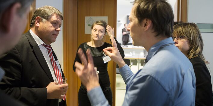Teilnehmer der Konferenz diskutieren in der Pause angeregt auf dem Flur