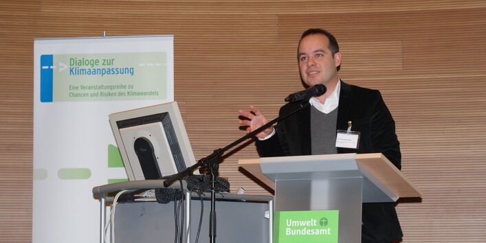 Dr. Alexander Ferstl von der Europäische Kommission, Generaldirektion für Klimapolitik, steht auf der Bühne hinter dem Rednerpult und hält seinen Vortrag