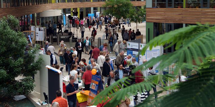 im UBA Dessau-Roßlau informieren sich viele Menschen an Infoständen und Plakaten
