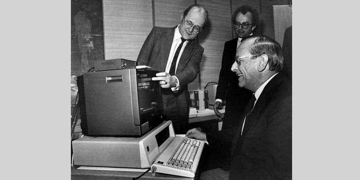 UBA-Präsident von Lersner zeigt anderen das Angebot "Bildschirmtext" an einem Monitor