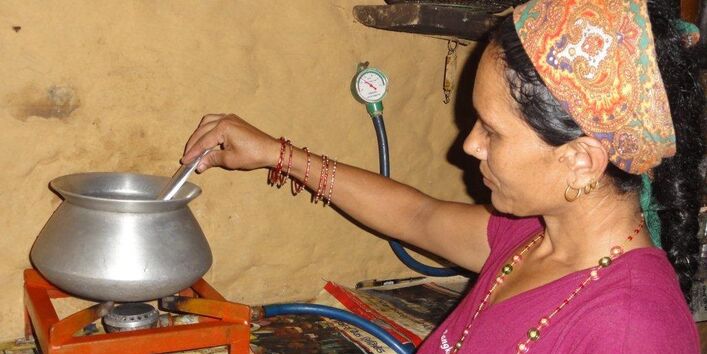 eine Frau in Nepal kocht zuhause auf einem kleinen Gaskocher