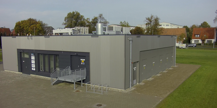 einstöckiges, quadratisches Betongebäude mit Flachdach, auf dem Dach einige technische Aufbauten