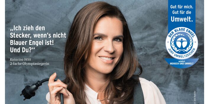 Katarina Witt mit einem Stromkabel mit Stecker und Schriftzug "Ich zieh den Stecker, wenn´s nicht Blauer Engel ist! Und Du? daneben das Logo "Blauer Engel"
