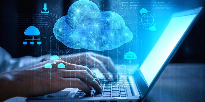 someone is typing on a laptop, with symbols for cloud computing such as clouds and download arrows above them